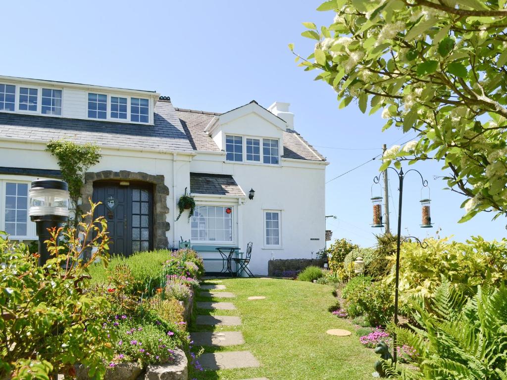 a white house with a garden in front of it at Salem Fach - Hw7587 in Llanrhwydrys