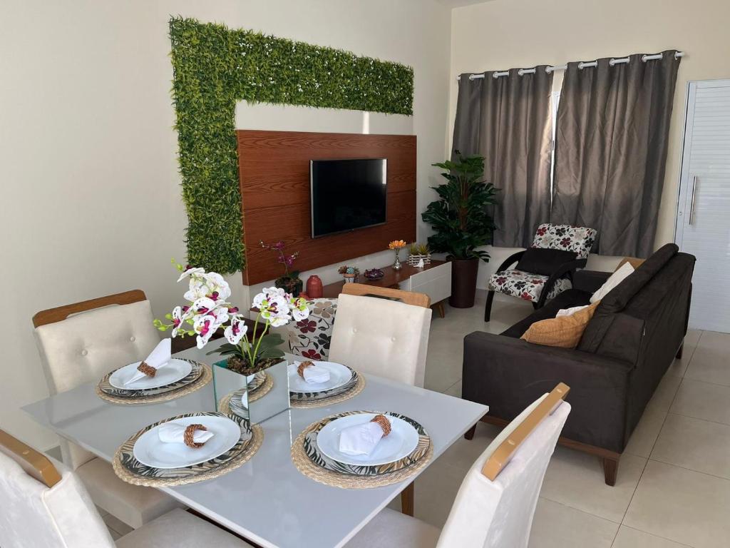 ein Wohnzimmer mit einem Tisch mit Platten und Blumen darauf in der Unterkunft Casa em Brotas Turismo de aventura in Brotas