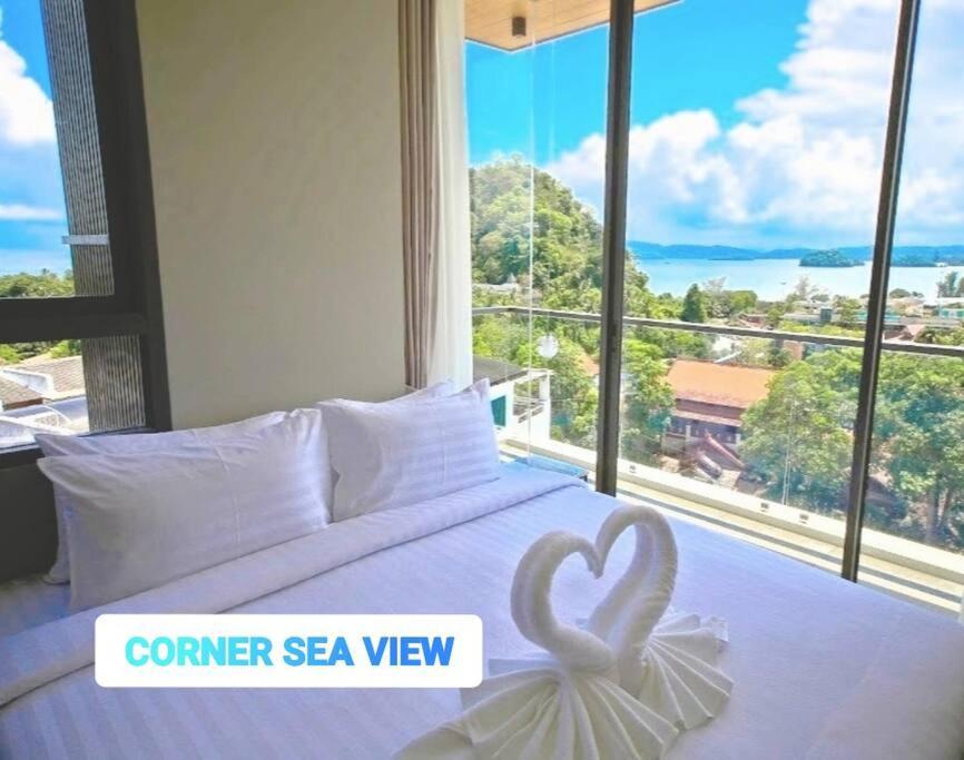 アオナンビーチにあるCORNER SEA VIEW KRABI Ao Nang 4 STARS HOTEL RESIDENCEのベッドルーム1室(ベッド1台、大きな窓付)