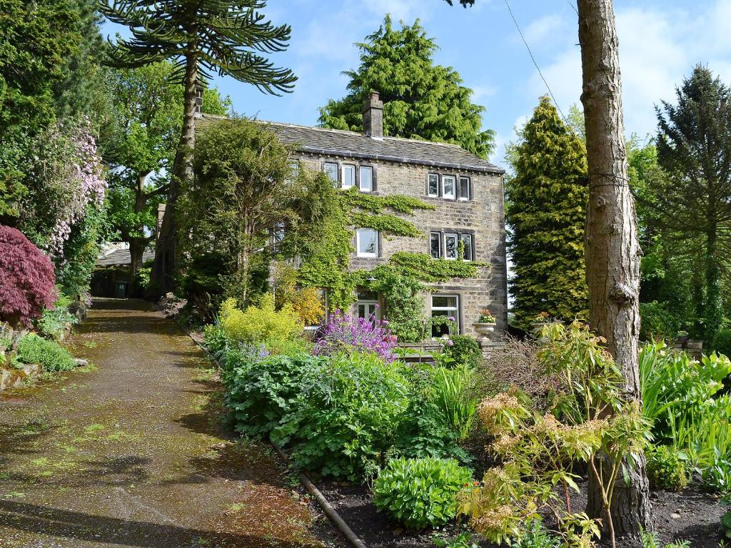 a garden in front of a stone house at Pear Tree House Annexe in Holmfirth