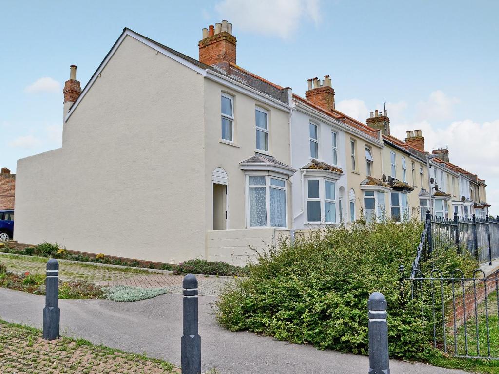 a white house with a fence in front of it at Ferrybridge View in Wyke Regis