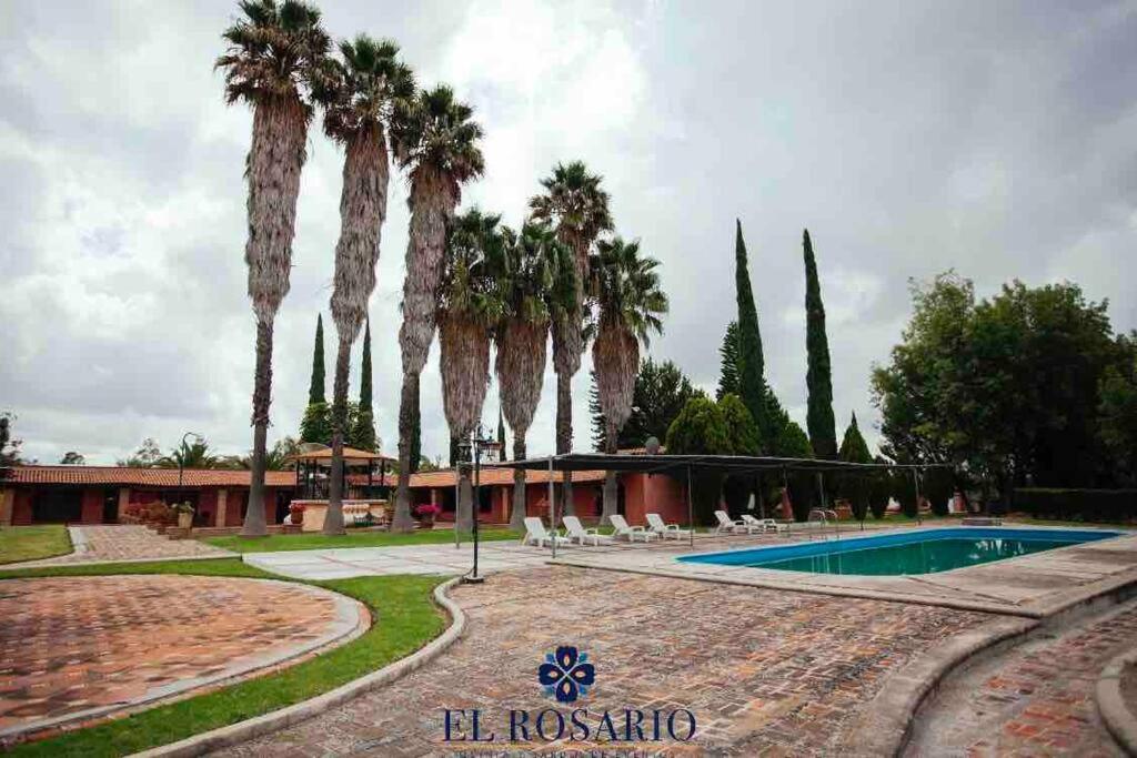 a resort with palm trees and a swimming pool at Quinta El Rosario maravilloso lugar in Lagos de Moreno