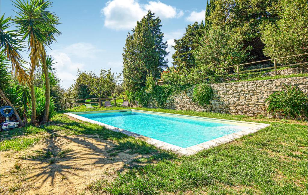 a swimming pool in a yard next to a stone wall at Beautiful Apartment In Castelanselmo With House A Panoramic View in Castell’Anselmo