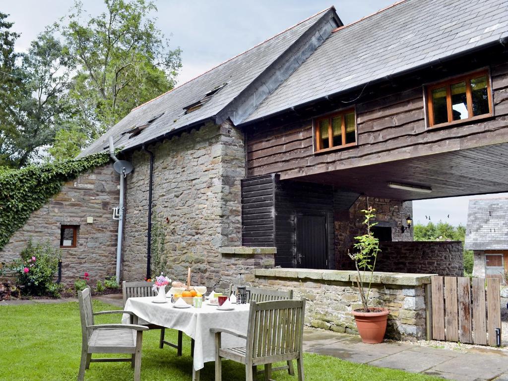 een tafel en stoelen voor een stenen huis bij The Bailey in Glasbury