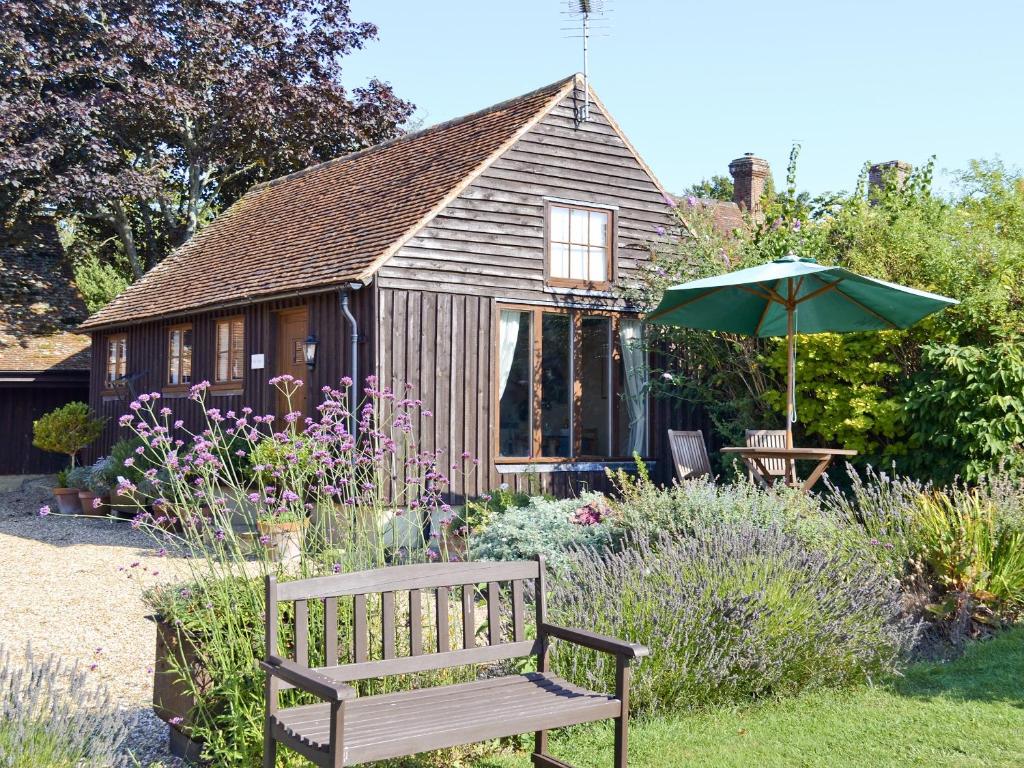 a wooden bench in front of a small house at The Dairy in Ninfield