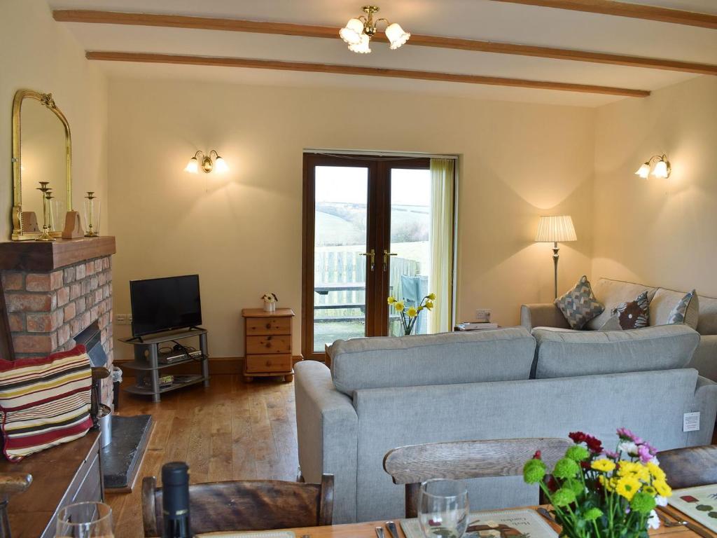 a living room with a couch and a tv at Ty Nant in Llanon