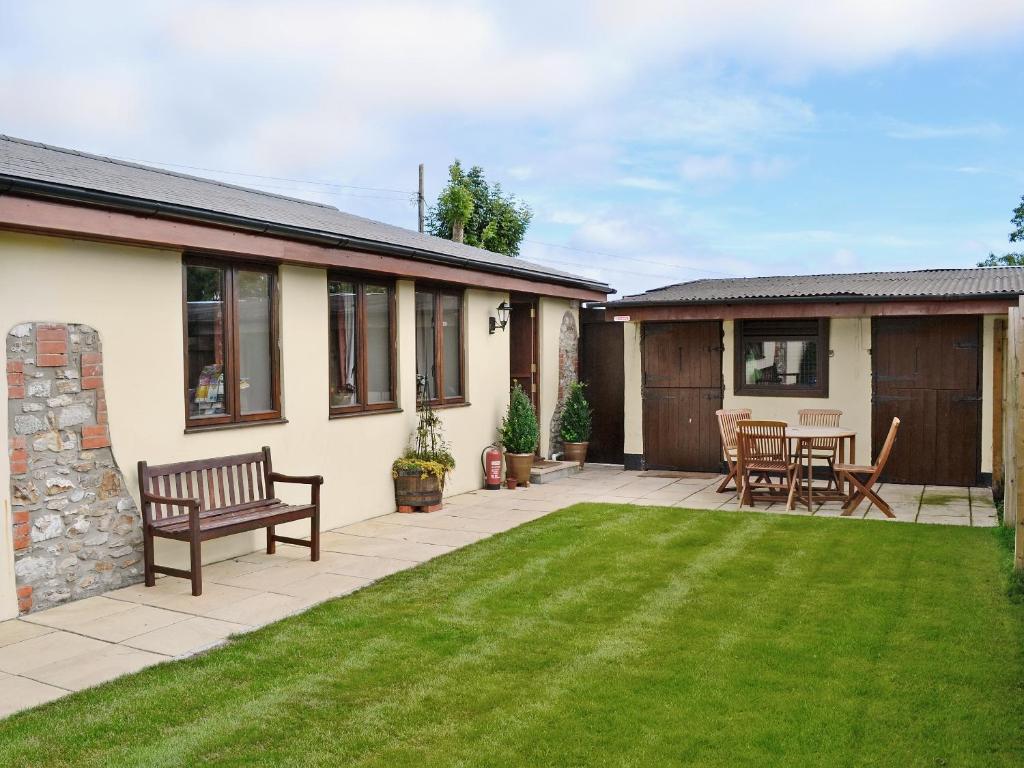 a garden with a bench and a table and chairs at Horseshoes - E5369 in West Buckland