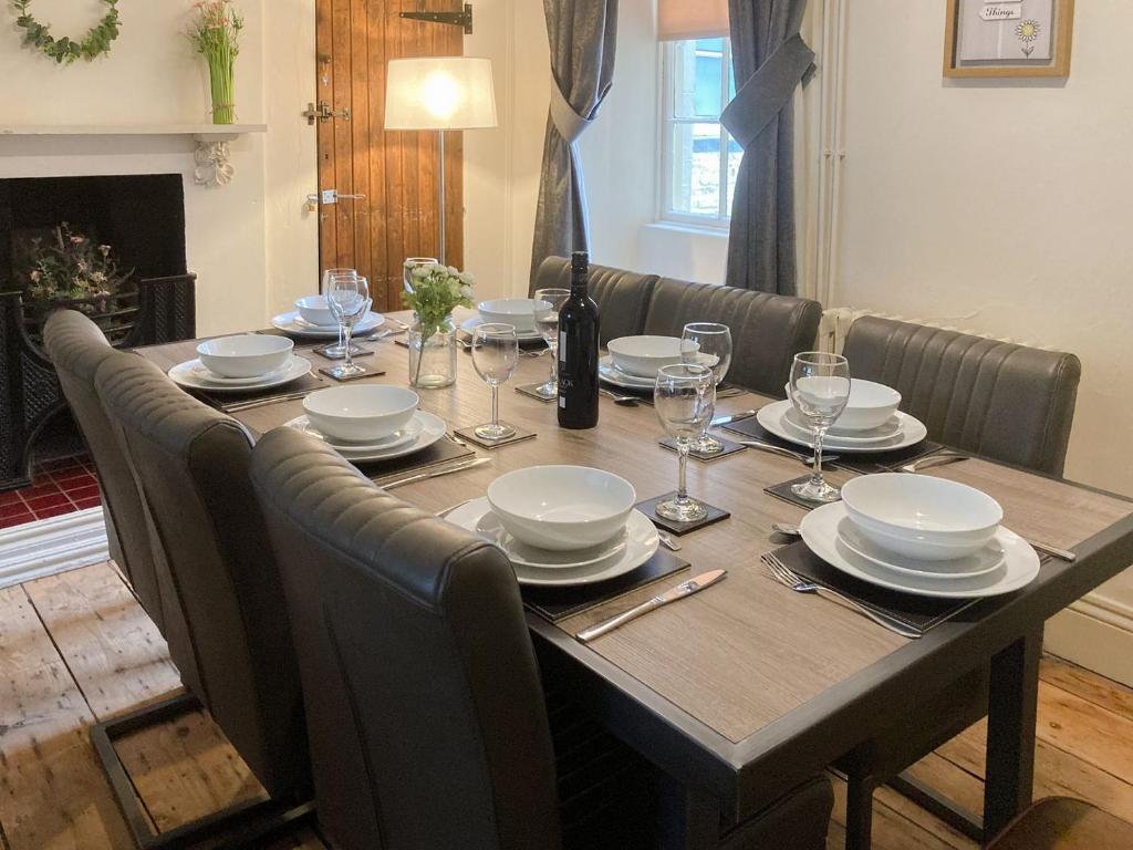 a dining room table with plates and wine glasses at Nells Cottage in Bridlington