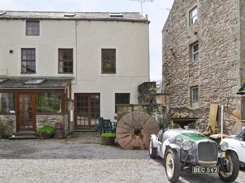 an old car parked in front of a building at The Corn Mill in Branthwaite