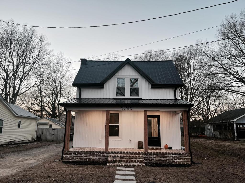 una pequeña casa blanca con techo negro en Peaceful Sears, Roebuck and Company Mail Order Home., en Henderson