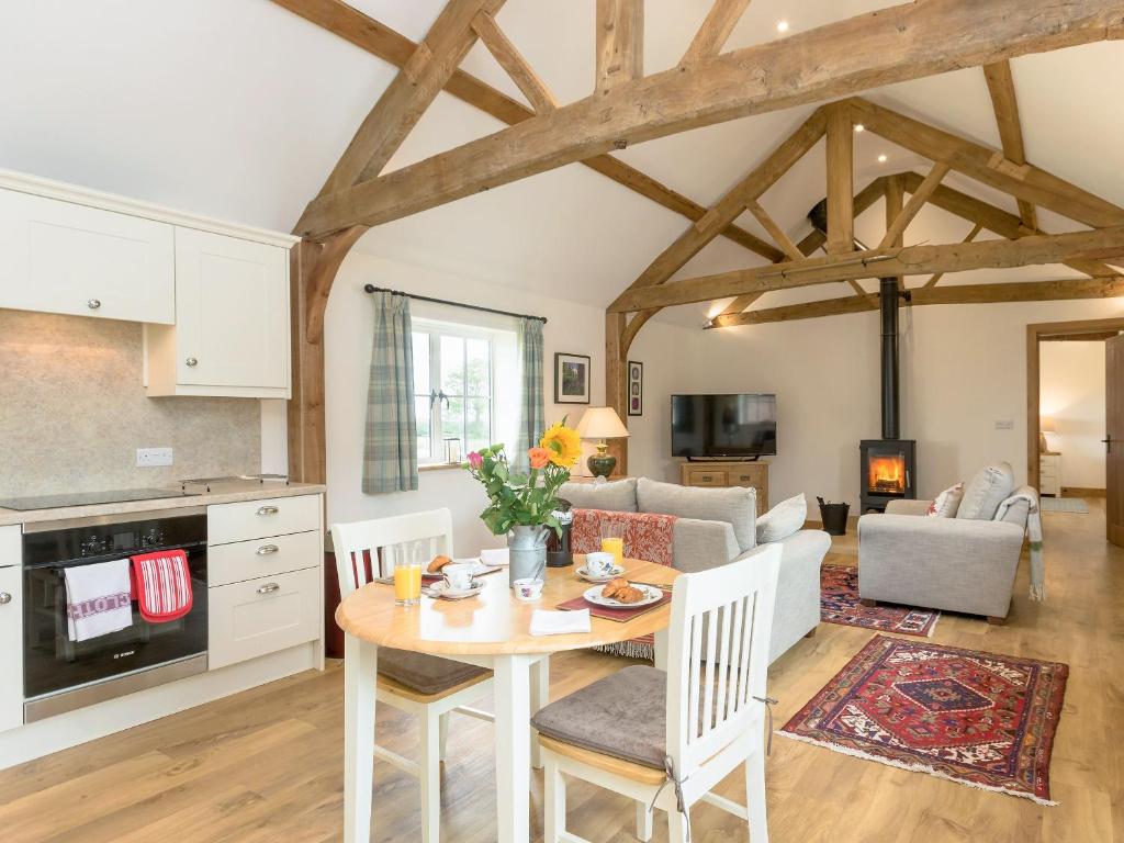 a kitchen and living room with a table and a couch at The Old Dairy-ukc2112 in Royal Wootton Bassett