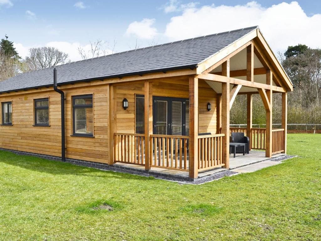 a large wooden cabin with a gambrel roof at Winston Lodge in Swinderby