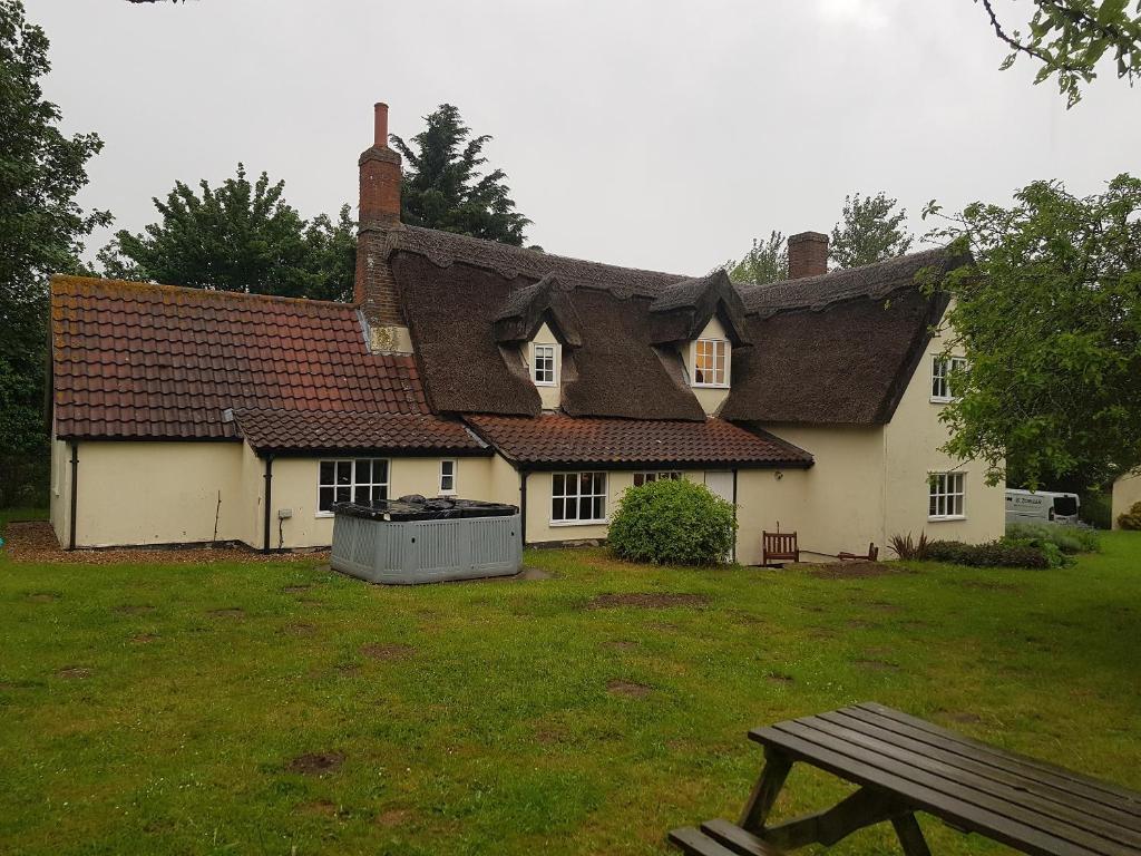 a house with a picnic bench in front of it at Burnt House Cottage in Barking