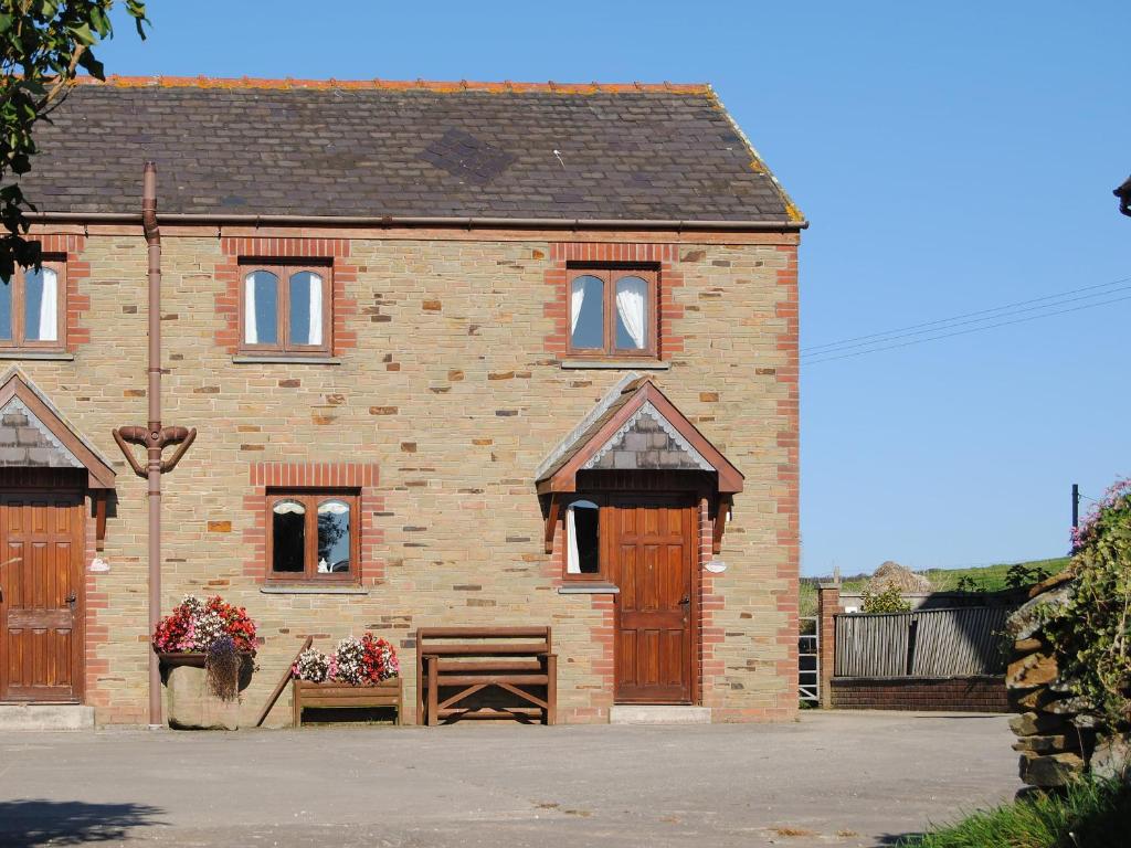 een stenen huis met twee deuren en een raam bij Merlin View in Saint Mawgan