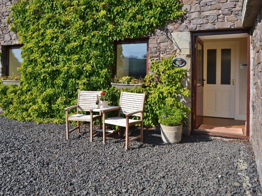 two chairs and a table in front of a building at The Wheelhouse in Kirk Yetholm