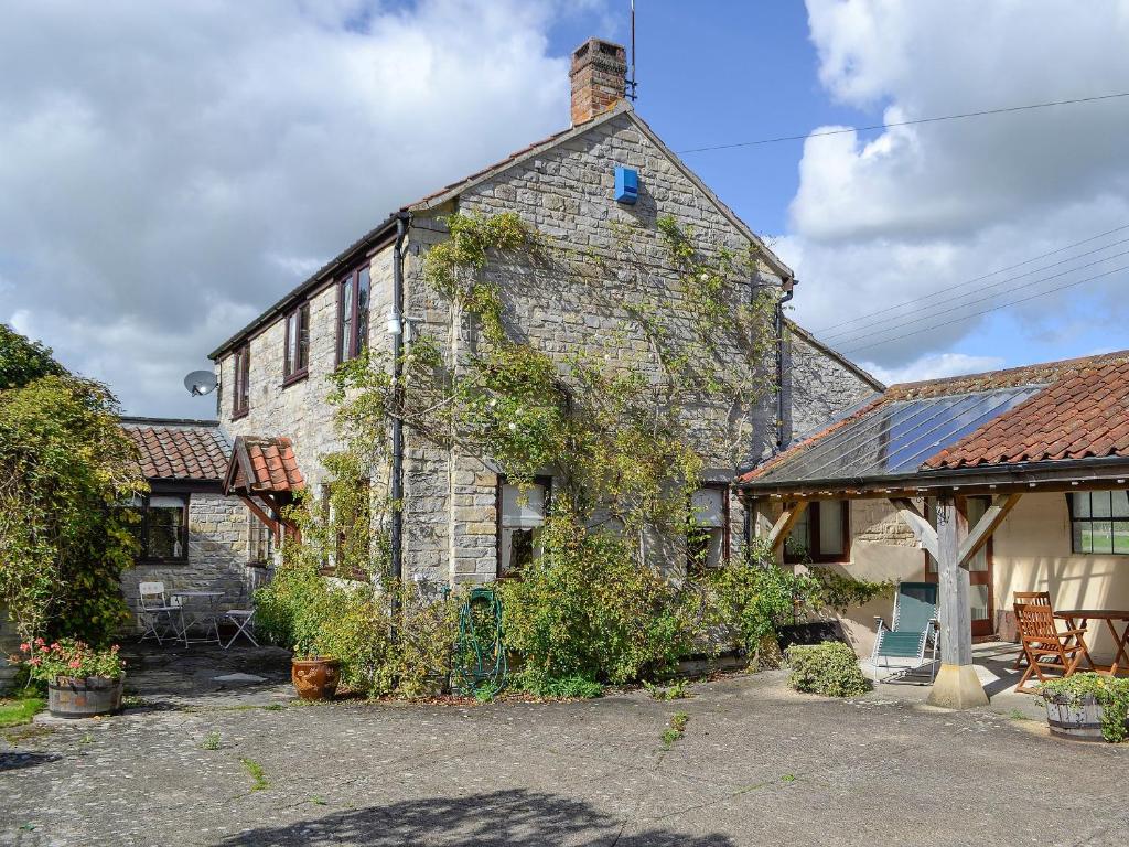 een oud stenen huis met klimop erop bij The Old Haybarn in Long Sutton