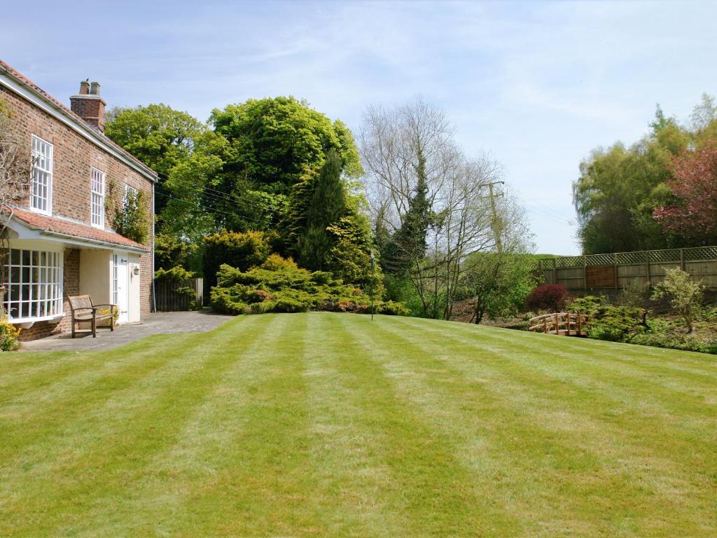 a large lawn in front of a house at Greenlands Farmhouse in Barmby on the Moor