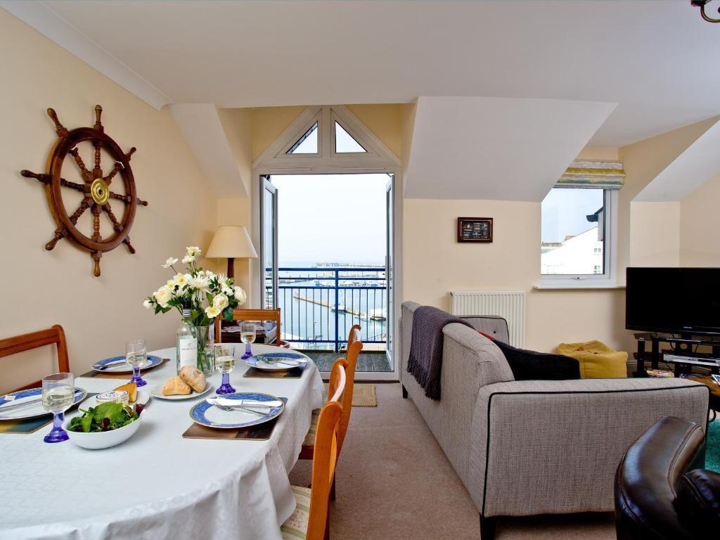 a living room with a table and a large window at 52 Moorings Reach in Brixham
