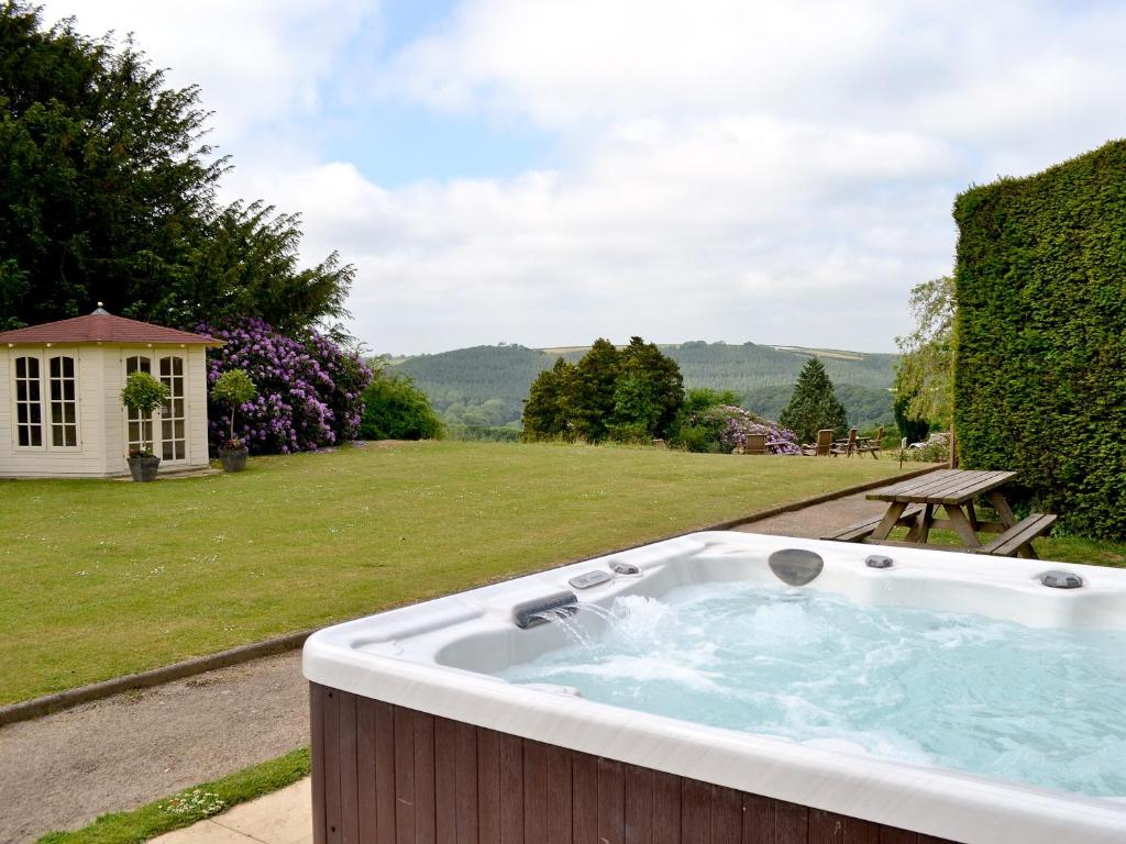 a hot tub in a yard with a picnic table at Beaford House in Beaford