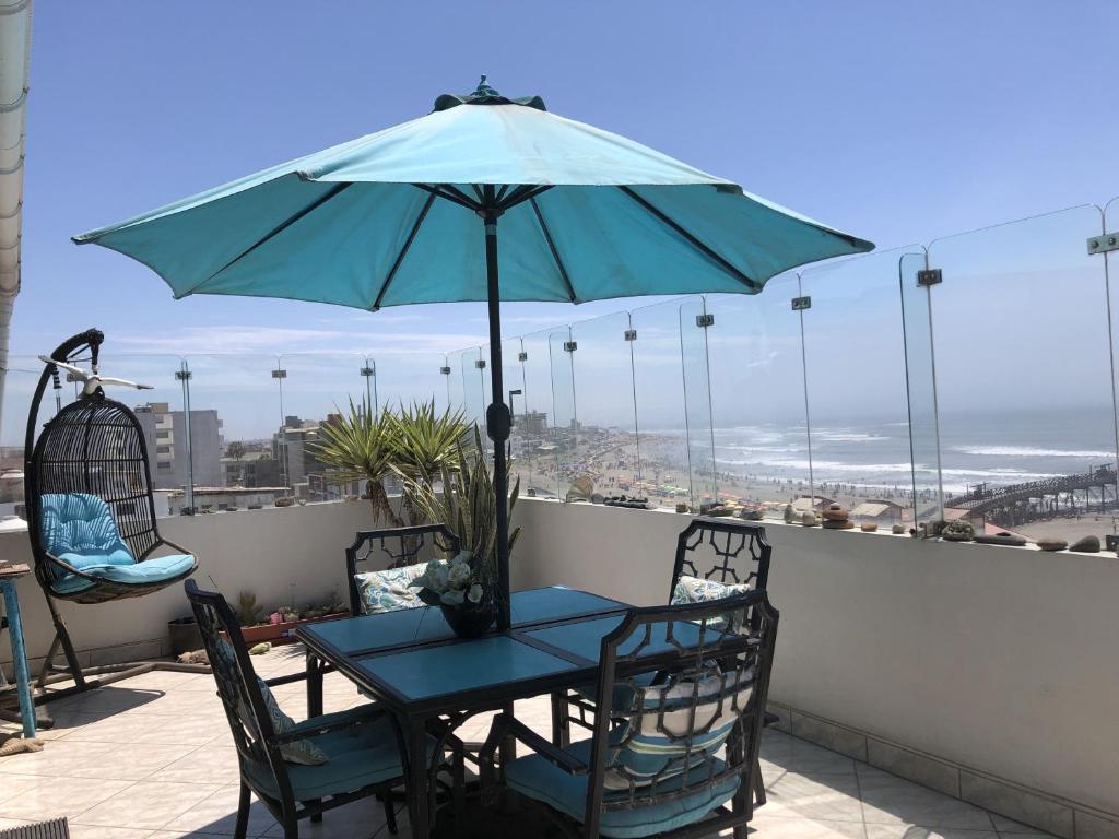 a table and chairs with an umbrella on a balcony at Best View of Pimentel in Pimentel