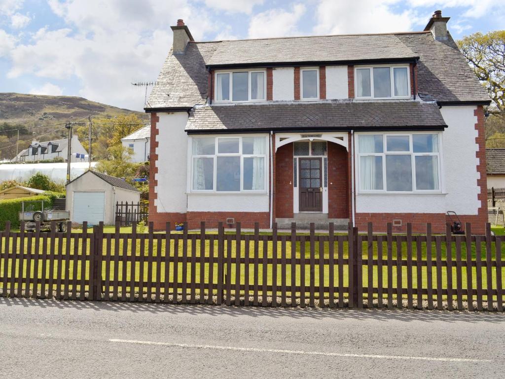 a yellow fence in front of a house at The Shieling in Lochranza