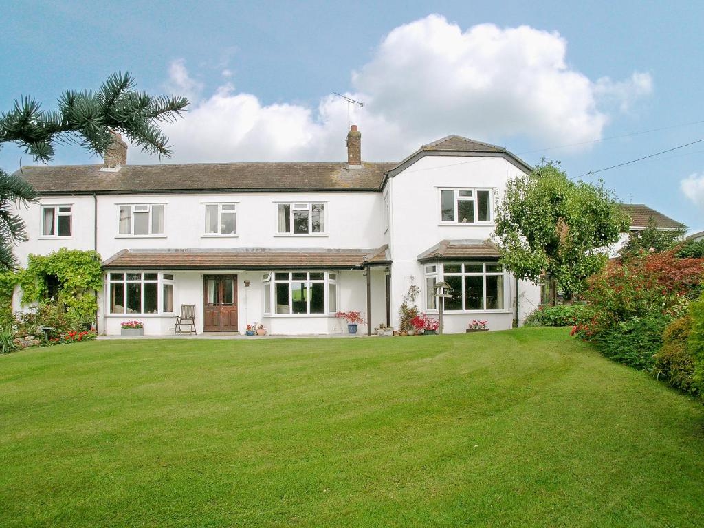 a large white house with a large yard at Abbotts Ball Farm in Potterne