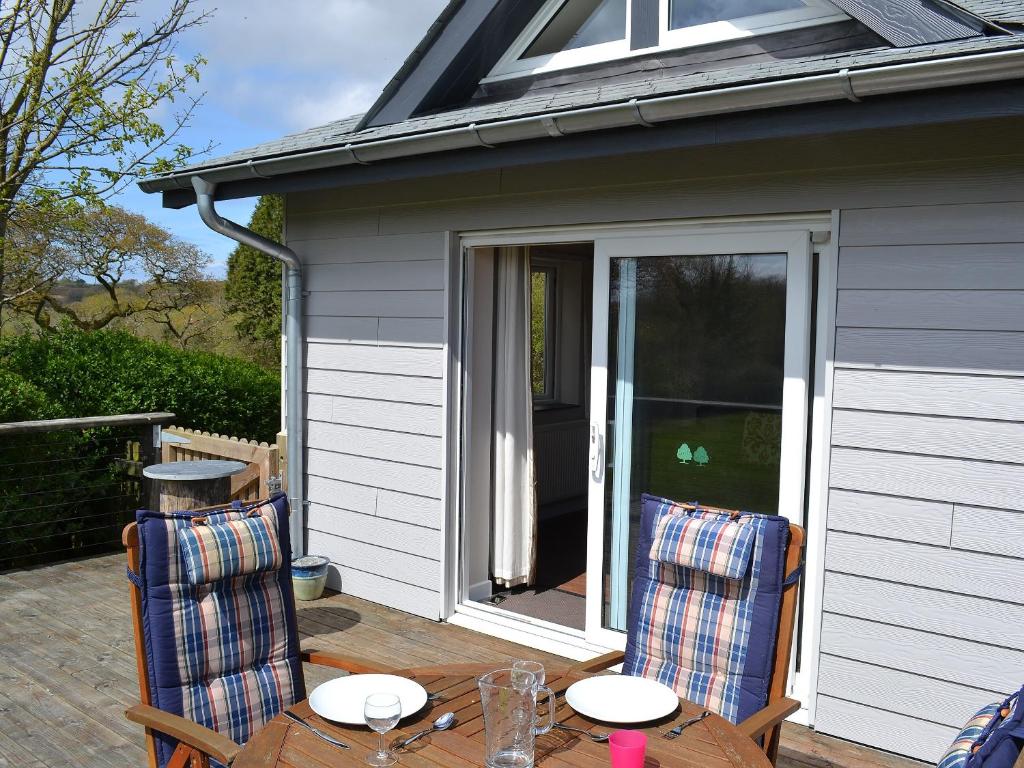 a patio with a table and chairs on a porch at Sunny Skies in St Austell