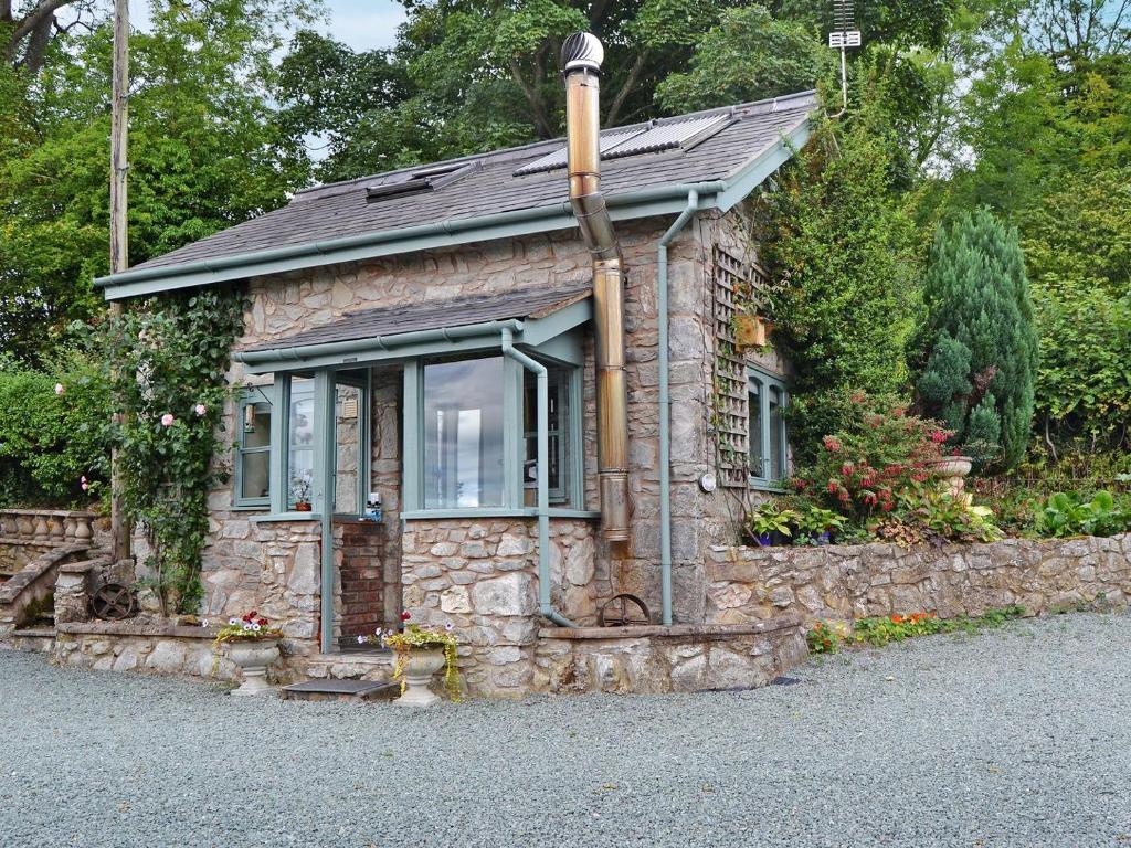 ein kleines Steinhaus auf einer Steinmauer in der Unterkunft The Pigsty Cottage E2783 in Llanyblodwel