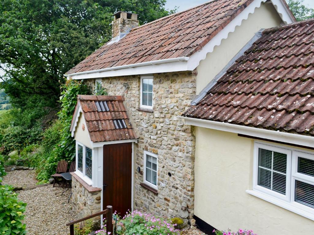 a stone cottage with a red roof at Oak Apple Cottage in Upottery