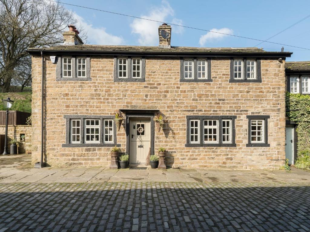 a brick house with a white door at Narrowgates Cottage in Barrowford