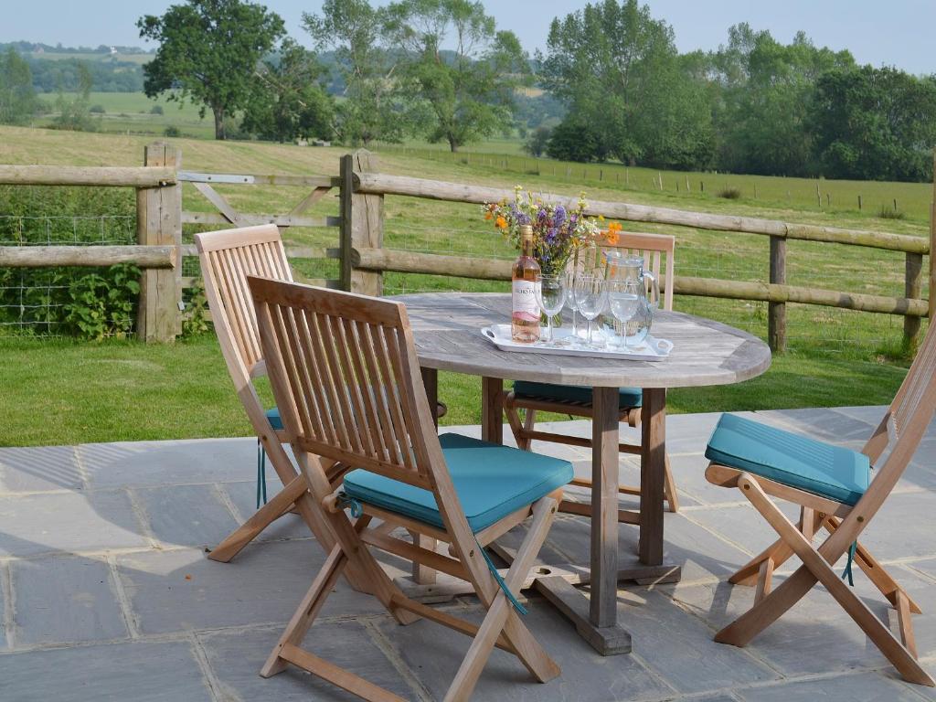 a table with two chairs and a vase of flowers on it at The Shearing Shed in Peasmarsh