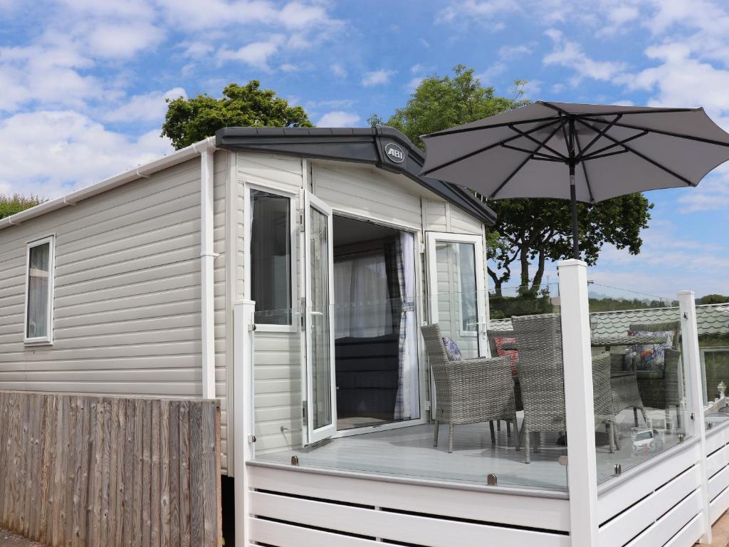 a house with an umbrella on a deck at The Retreat in Budleigh Salterton
