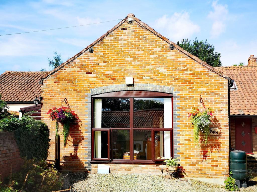 a brick house with a large window on it at Elm Barn Lodge in Southampton