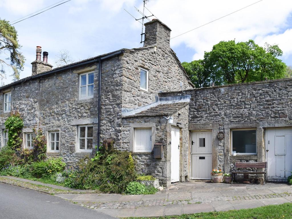 an old stone house on the side of a street at Foss Gill in Starbotton