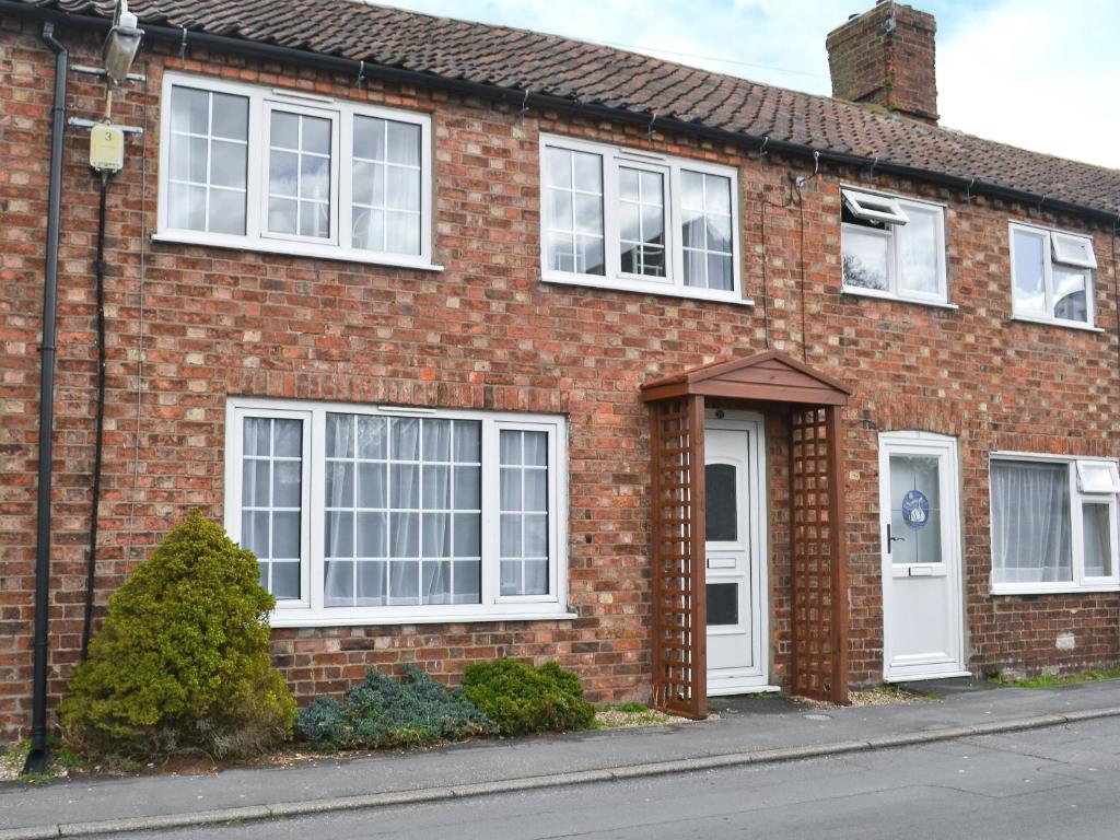 a brick house with white doors and windows at Banovallum Cottage in Horncastle