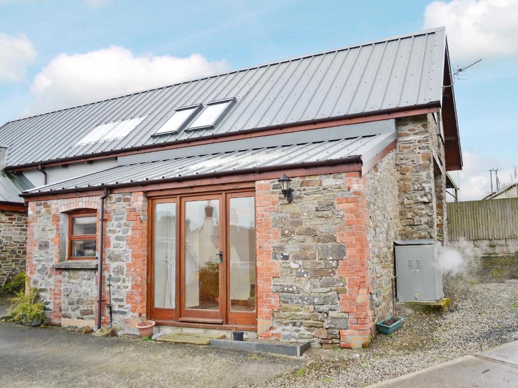 uma casa de tijolos com telhado de metal e janelas em Taw em Great Torrington