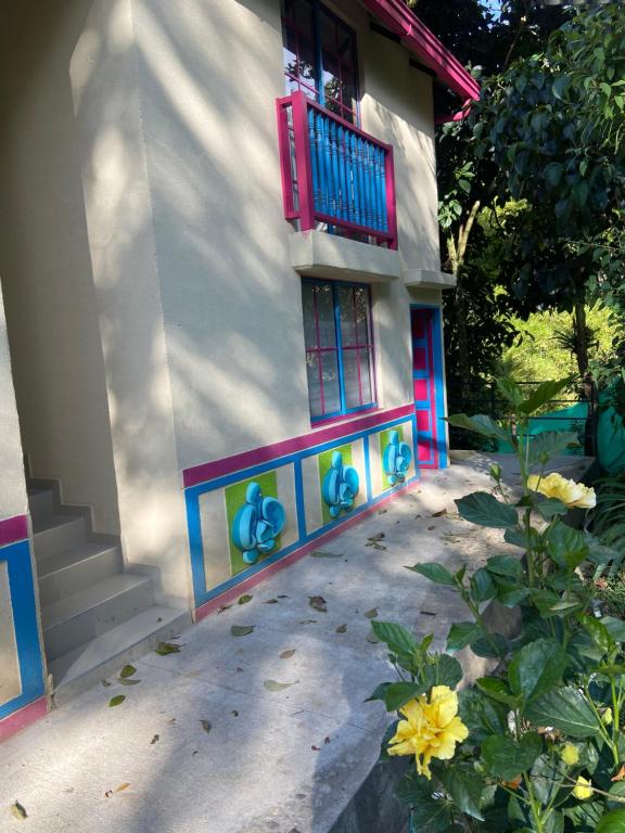 una casa con una ventana roja y una flor amarilla en Aparta Hotel Jardines de Guatape By Hope, en Guatapé