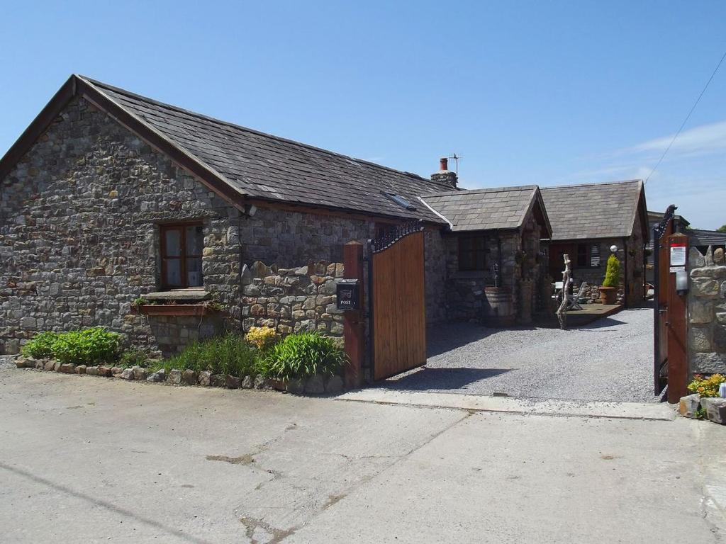 an old stone building with a wooden gate at The Willows in Parkmill