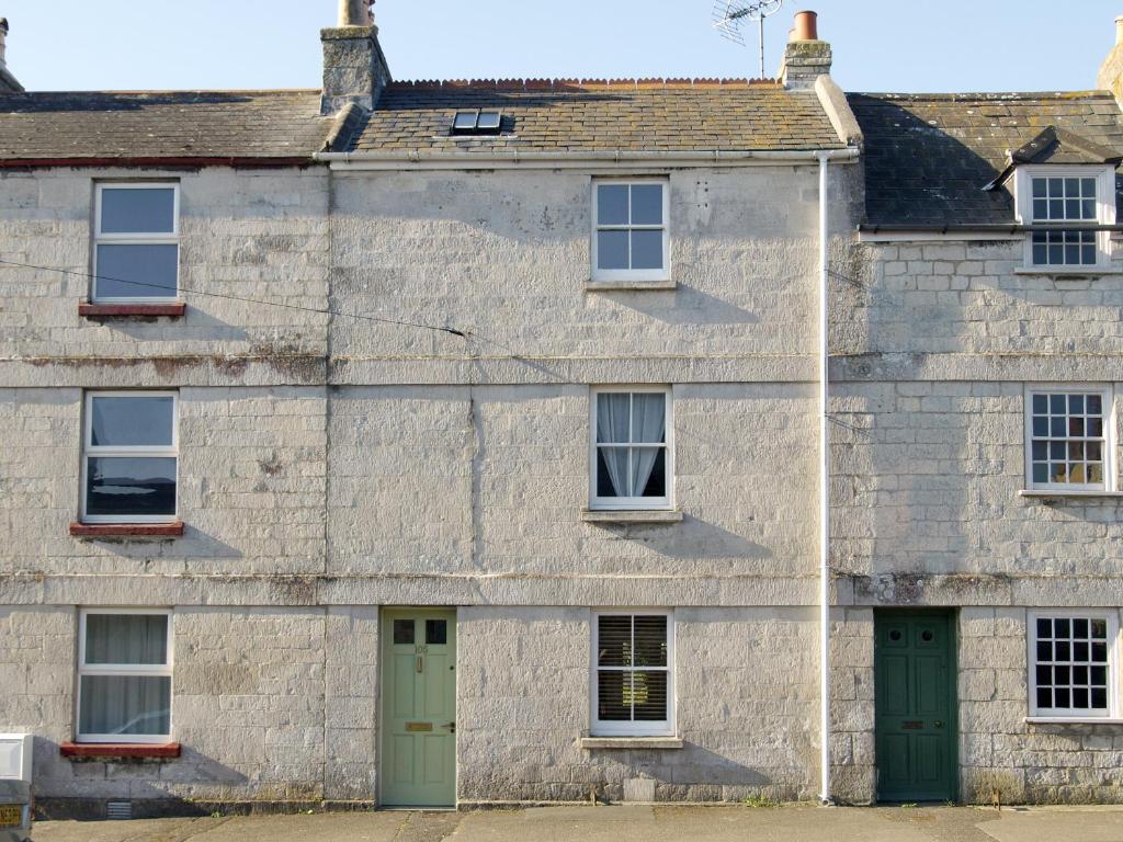 an old stone house with green doors and windows at Lime Cottage in Portland