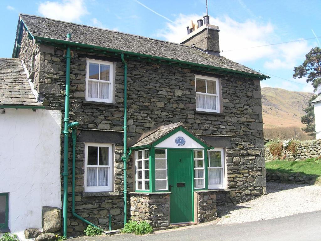 an old stone house with a green door at 3 Townhead Cottages in Grasmere