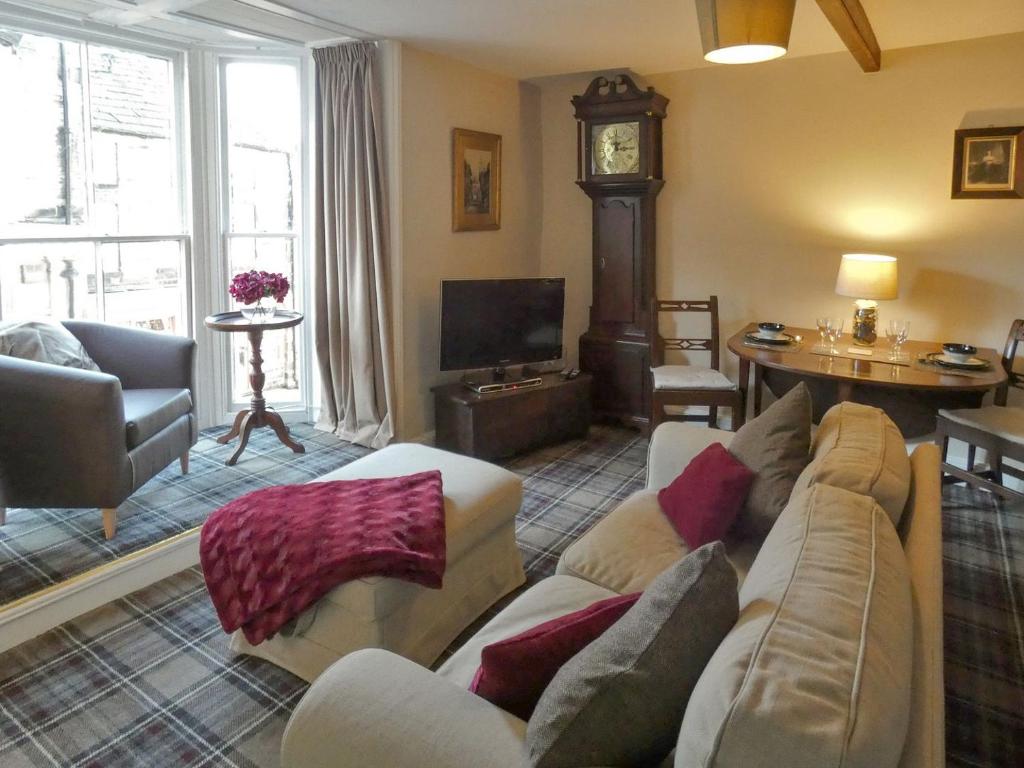 a living room with a couch and a tv at The Old Clockmakers in Pateley Bridge