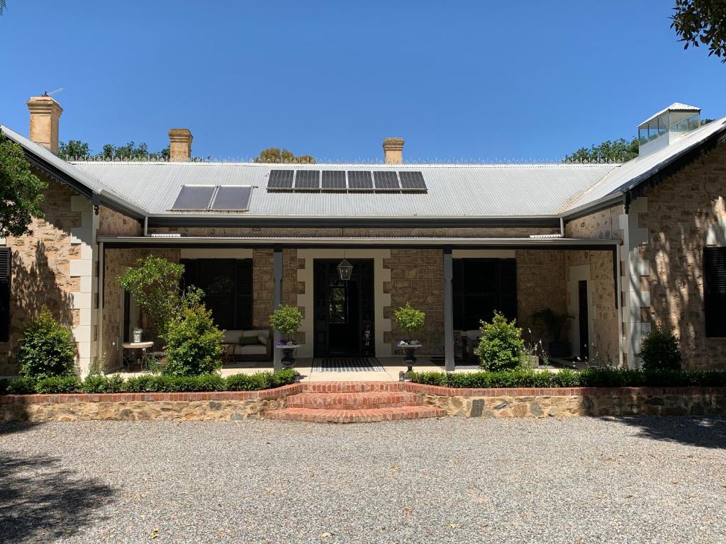 une maison en briques avec des panneaux solaires sur le toit dans l'établissement Bungala House, à Yankalilla