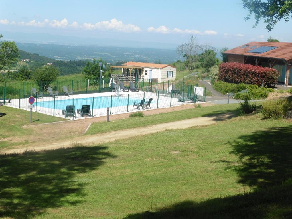 a swimming pool in a yard with a house at Camping le Montbartoux in Vollore-Ville