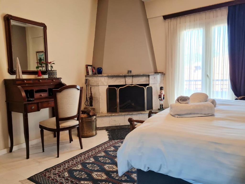 a bedroom with a bed with a fireplace and a mirror at Papastavrou Apartments in Kalavrita