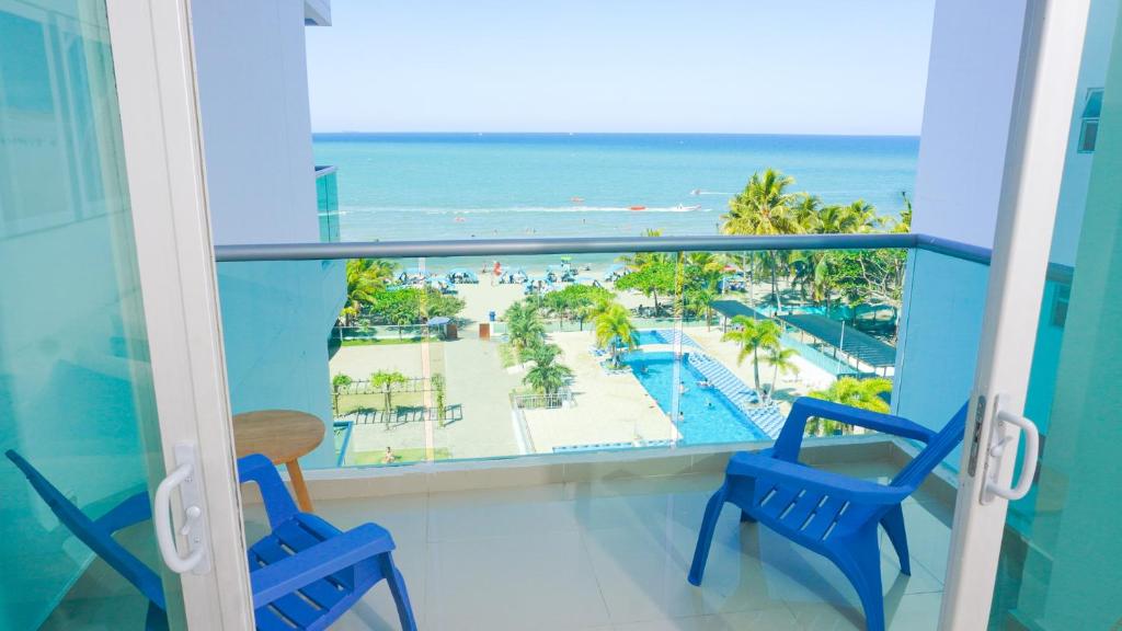 balcón con sillas azules y vistas a la playa en Magico Apartamento Frente al Mar 3 Habitaciones AR53, en Coveñas