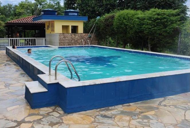 a large swimming pool with blue water in a yard at Apartamento Martin de Sá in Caraguatatuba