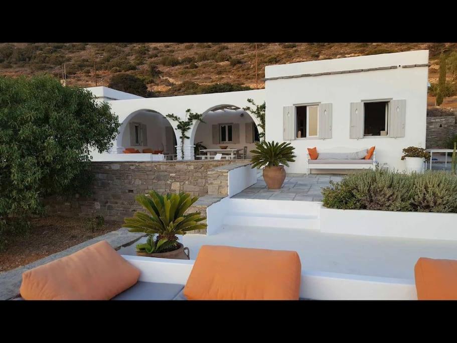 a white house with two orange chairs in front of it at Cycladic Villa Kamari in Kampos Paros