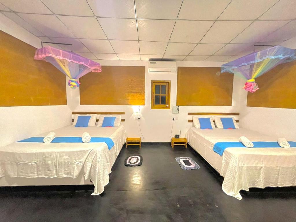 2 camas en una habitación con cometas en el techo en Tusker's Paradise Safari Villa, en Udawalawe