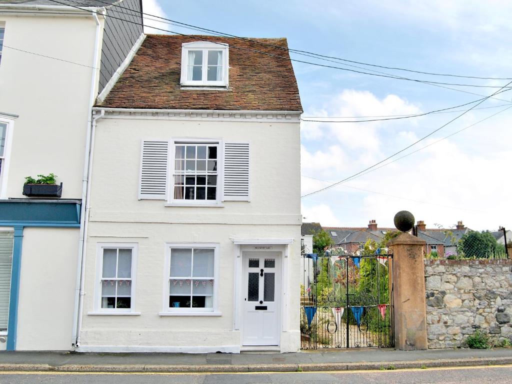 a white house on a street with a fence at Solent Cottage - Pqqu in Yarmouth