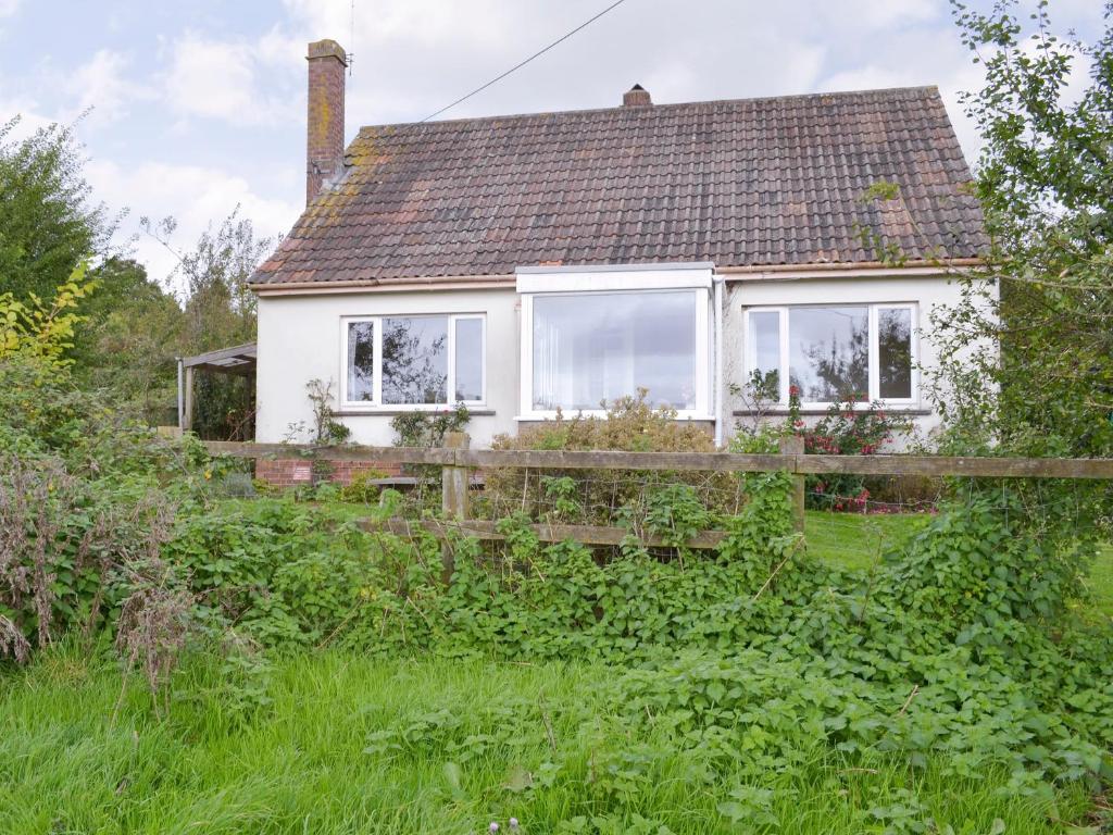 uma casa branca com um telhado castanho em Walters Cottage em Pilton